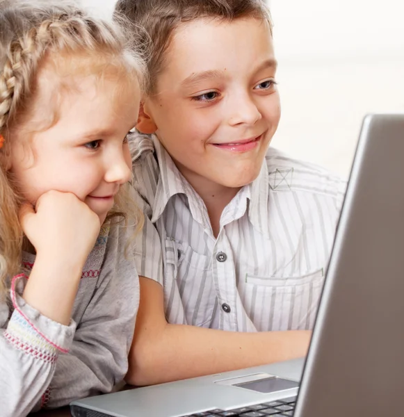 Crianças felizes jogando laptop em casa — Fotografia de Stock