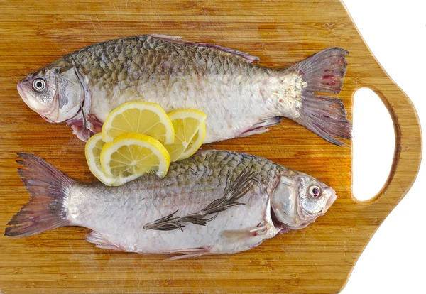 Свежая рыба на борту с лимоном — стоковое фото