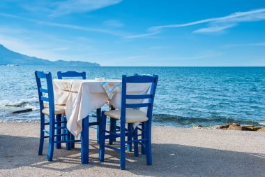 Blue chairs and table in typical Greek tavern near the sea in Kissamos town. Crete, Greece