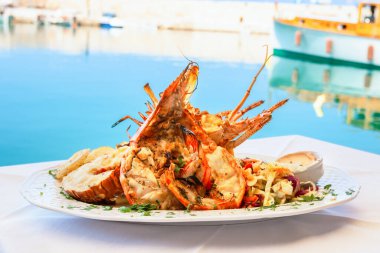 Rethymno 'daki deniz kenarındaki tavernada geleneksel ıstakoz yemeği. Girit, Yunanistan