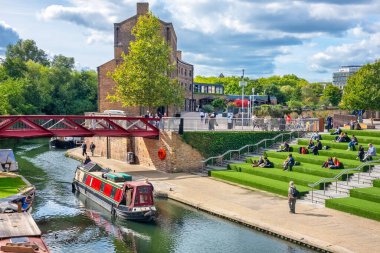 Londra, İngiltere - 17 Eylül 2025: Canalside Green Steps kanalında dinlenen insanlar