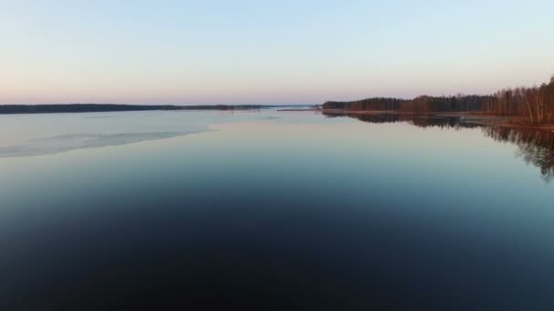 4К. Низкий полет над диким озером ранней весной на закате, вид с воздуха . — стоковое видео