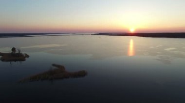 4k. Gün batımında erken ilkbaharda köprü ile büyük donmuş göl üzerinde Uçuş, havadan görünümü.