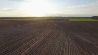 4 k. uçuş yukarıdaki taze ekili alanları Tarım makineleri, havadan panoramik görünümü ile gün batımında.