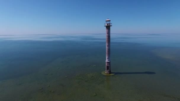 4К. Полет над старым маяком, стоящим в море, панорамный вид с воздуха. Эстония, остров Сааремаа - Kiipsaare tuletorn . — стоковое видео