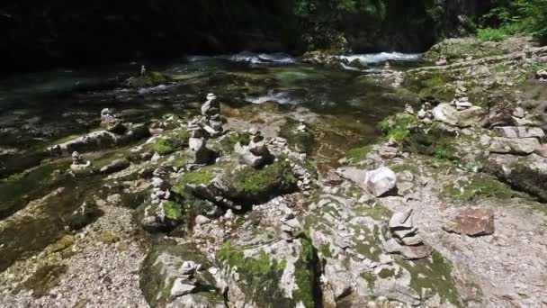 4k. wild Radovna rivier stroomt in Vintgar Gorge en stenen piramides, gemaakt door mensen. Schoon blauw water en groen bos. Triglav Nationaal Park, Julische Alpen, Bled vallei, Slovenië, Europa. — Stockvideo