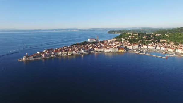 Vuelo sobre la ciudad vieja Piran en Eslovenia, vista panorámica aérea con casas antiguas, Iglesia Parroquial de San Jorge, fortaleza y el mar . — Vídeos de Stock