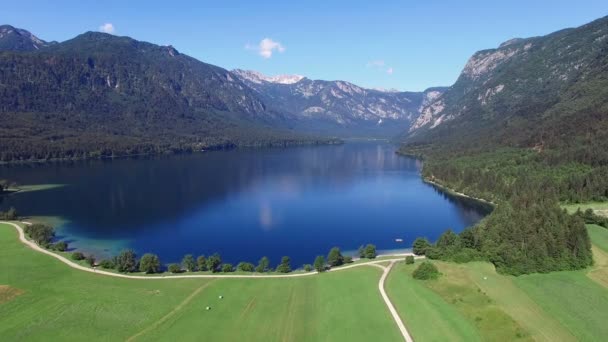 4K. Alto vuelo y despegue por encima del increíble lago Bohinj en la mañana. Aguas profundas azules y montañas de los Alpes Julianos. Parque Nacional de Triglav, Eslovenia, Europa . — Vídeos de Stock