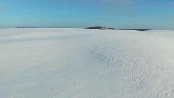 Voo e decolagem acima de campos de neve no inverno, vista panorâmica aérea. Padrão de neve e textura. Deserto de neve . — Vídeo de Stock