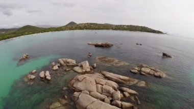 Su, Corsica, Santa Giulia beach taşlar ve kayalar ile deniz üzerinde uçuş. Havadan panoramik görünümü.