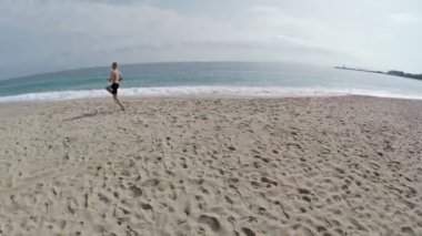Adam sahil deniz arka plan ile çalışıyor. Uçuş ve kalkış boyunca, havadan görünümü. Fransa, Corsica.