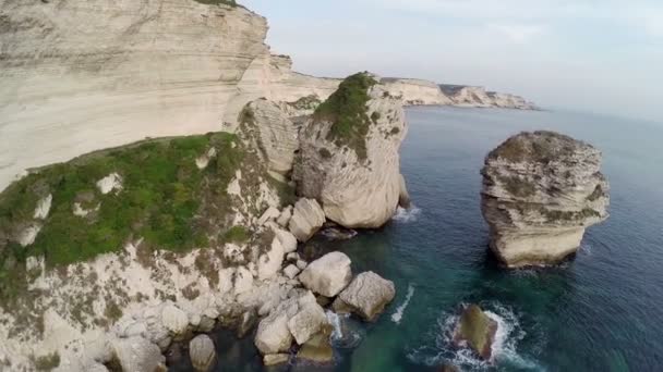 Flight and takeoff over Bonifacio bay area at sunset colors. Rocks and sea. Corsica, France. Aerial panoramic view. — Stock Video