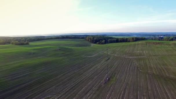 4K. Vuelo sobre verdes colinas y campos al atardecer, vista panorámica aérea . — Vídeos de Stock