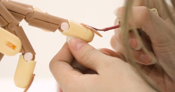 Donna sta dipingendo unghie rosa smalto sulla mano protesi, primo piano vista laterale. — Video Stock