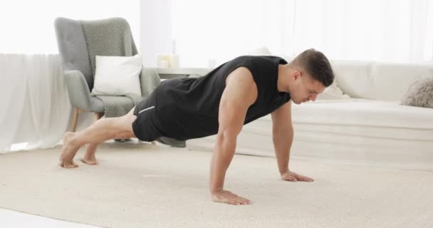 Jeune homme fait des exercices push-ups à la maison en se gardant pendant le confinement. — Video
