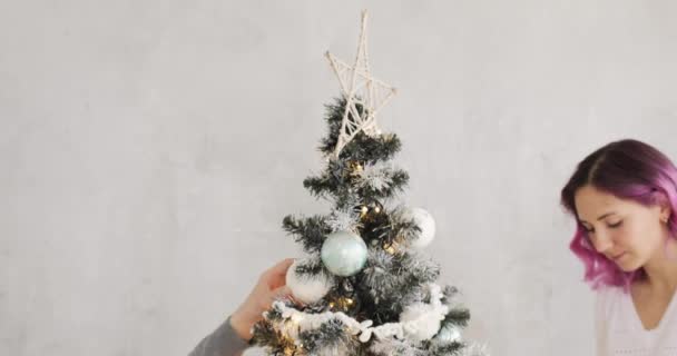 행복 한 가족 남편과 아내가 집에서 크리스마스 트리를 함께 장식하고 있습니다. — 비디오