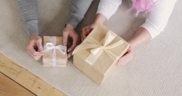 Сімейний чоловік і жінка лежать на підлозі розпаковують подарункові коробки на Різдво вдома . — стокове відео