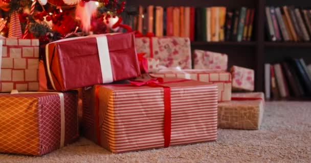 Vörös dobozok és ajándékok ennek a vonzáskörzetében: Karácsonyfa a padlón Éva, kamera mozgásban. — Stock videók
