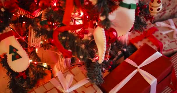 Noel ağacının yanındaki hediye kutuları kırmızı renklerde, kamera hareket halinde.. — Stok video