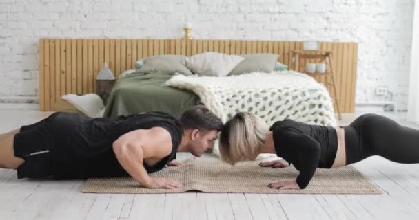 Fitness çifti şınav çekiyorlar ve evde birbirlerine beşlik çakıyorlar.. — Stok video