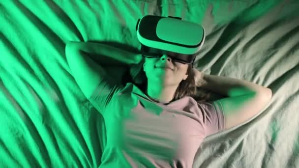 Kobieta leży w łóżku w wirtualnej rzeczywistości okulary 3D i oglądanie wideo. — Wideo stockowe