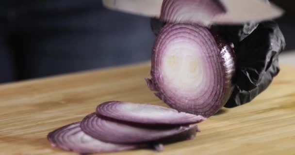Cocinar en guantes cocinar cortando cebolla roja fresca sobre tabla de madera, manos de cerca. — Vídeos de Stock