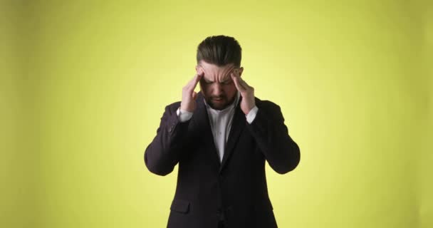 Malade homme barbu en costume de bureau mettre les mains sur la tête ayant mal à la tête. — Video