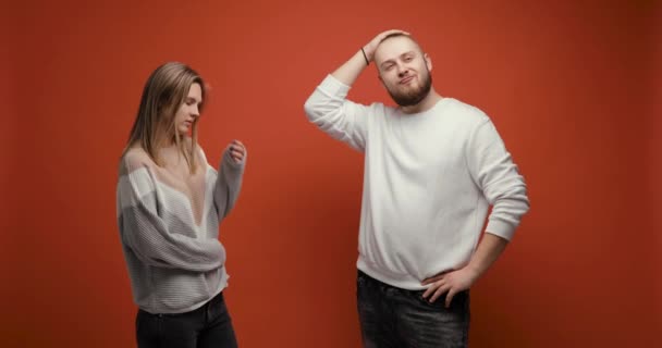 Narciso hombre muestra su forma física a la mujer joven sobre fondo rojo. — Vídeos de Stock