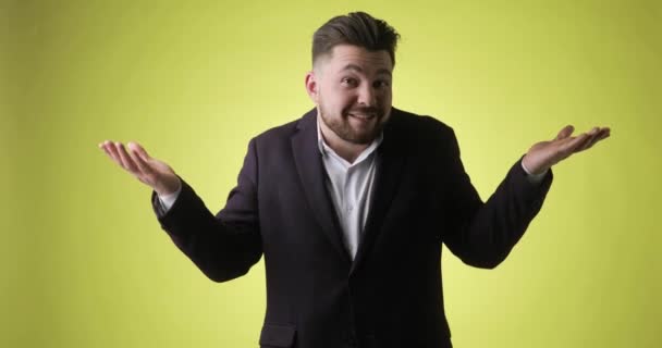 Hombre barbudo sonriente confuso en traje de oficina gestos que no sé, no tengo idea. — Vídeos de Stock