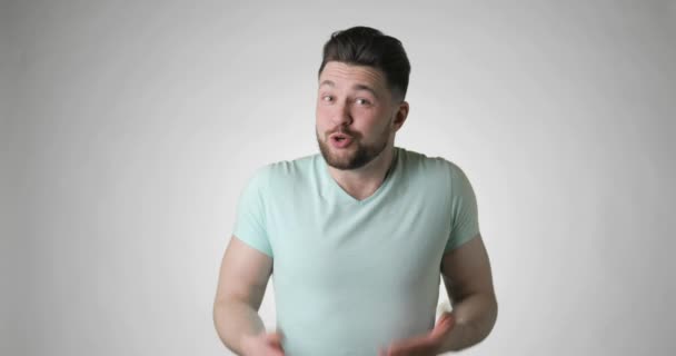 Confused smiling bearded man in t-shirt gestures i dont know, have no idea. — Stock Video