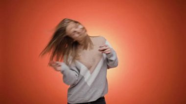 Son derece mutlu, kapüşonlu genç bir kadın. Neşeli bir şekilde dans ediyor..