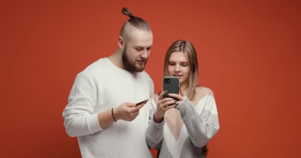 Glückliches Paar Frau und Mann kaufen online mit Smartphone und Kreditkarte. — Stockvideo