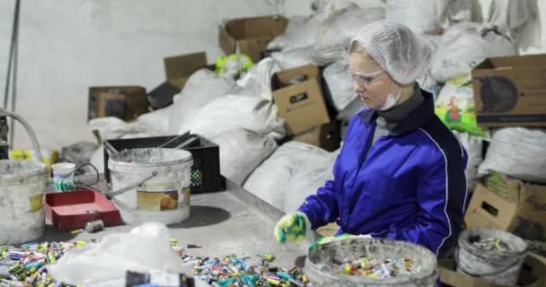 Person in uniform and gloves sorting used batteries. — Stock Video