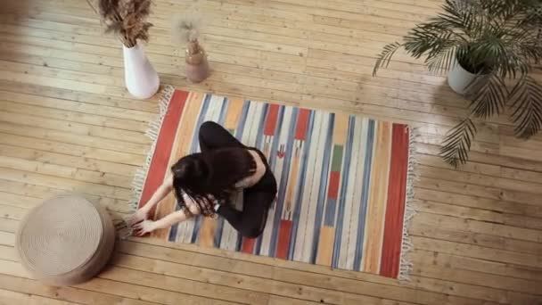 Vue du dessus d'une jeune femme faisant de l'exercice sur un plancher de bois. — Video