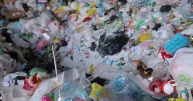 Çeşitli atık yığınları, plastik kapaklar, selofan poşetler, kağıt.