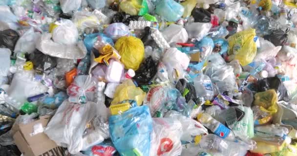 Abfall vor der Verarbeitung. Haufenweise Müll, Plastikdeckel, Zellophanbeutel, Papier. — Stockvideo