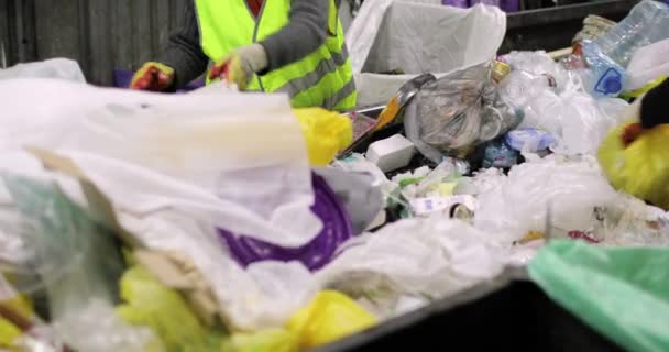 Müllcontainer. Ein Haufen verschiedener Abfälle, Plastik, Zellophan. Menschen in Handschuhen sortieren den Müll von Hand. Nahaufnahme. — Stockvideo