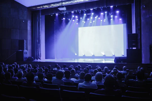 As pessoas estão à espera que o orador fale, palco vazio. Concentra-te no palco. foto tonificação azul — Fotografia de Stock