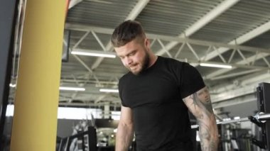 Spor salonunda pazı egzersizi yapan atletik bir genç..