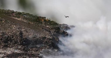 Çöp sahasındaki yangından kaynaklanan hava kirliliği. Atık arazinin üzerinde duman bulutları, çöplük yangını, atıkların atık sahalarında yakılması ve yayılması.