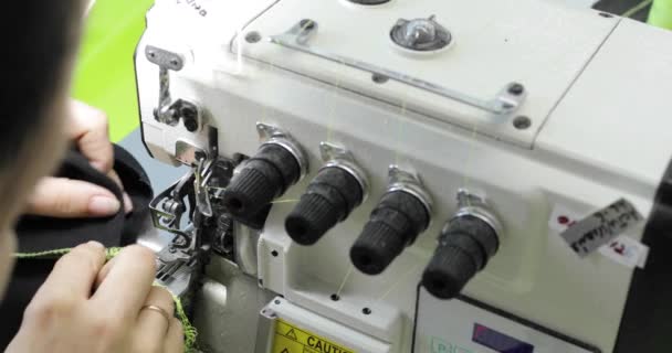 Four-thread overlock Sewing Machine. Female hands working on Tailoring. Close-up. — Stock Video