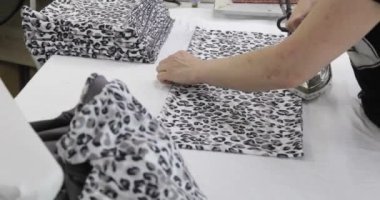 Profesyonel bir terzinin elleri. Snoodları ütülemek, dikiş atölyesinde elbise dikmek..