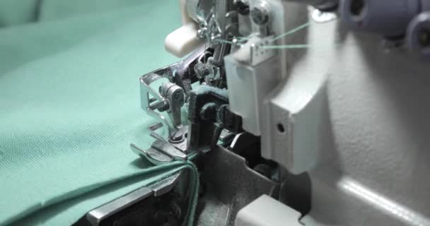 Overlock Maszyna do szycia. Ręce profesjonalnego krawca pracującego nad krawiectwem. Automatyczna maszyna do szycia tekstyliów przemysłowych. — Wideo stockowe