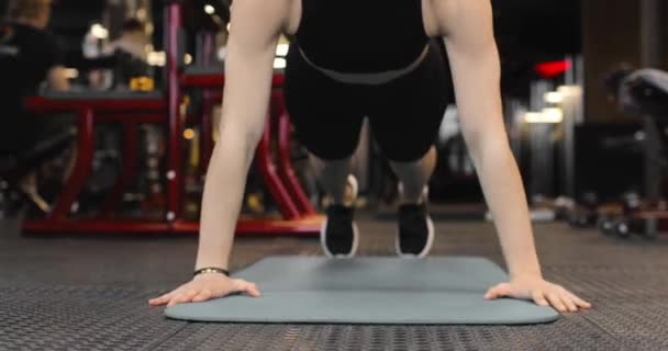 Wanita muda sporty melakukan push-up di gym. Atlet terlibat dalam kebugaran. Tampilan depan. — Stok Video