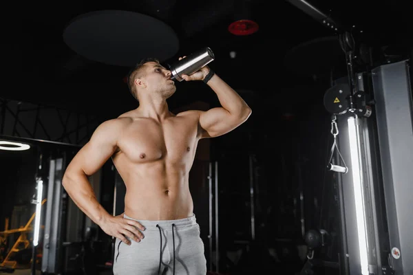 Muscular man in gym with shaker. Strong male abs, bodybuilding concept background. Bodybuilder in the gym. — Stock Photo, Image