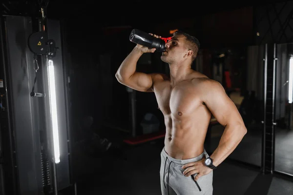 Hombre musculoso en el gimnasio con agitador. Abdominales masculinos fuertes, fondo concepto de culturismo. Culturista en el gimnasio. —  Fotos de Stock