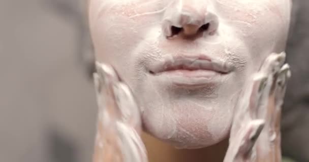 Крупним планом нижня частина молодої жінки стикається, миючи обличчя органічним пінистим засобом для чищення. Дівчина очищає шкіру обличчя, робить масажні рухи. Вид спереду . — стокове відео