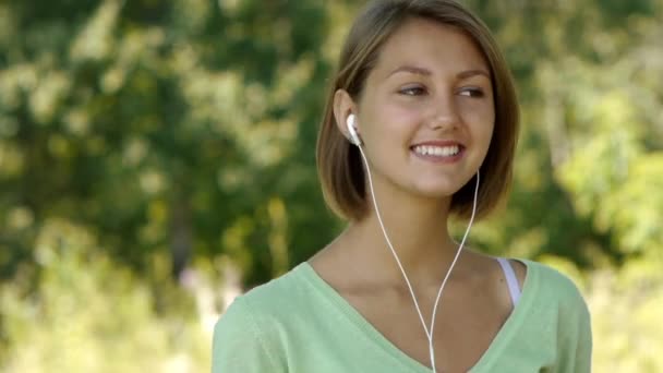 Young woman listening to music through headphones — Stock Video