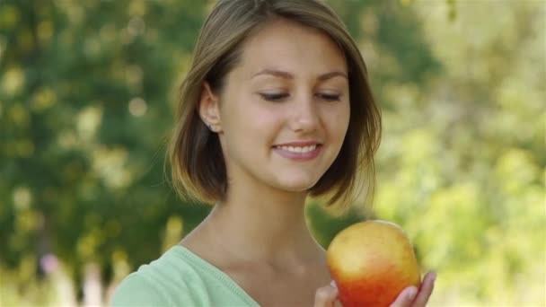 Sonriente hermosa joven con manzana — Vídeo de stock