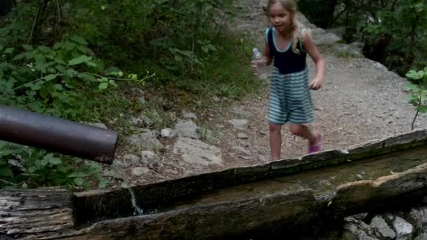 Little girl is drinking water from spring — Stock Video